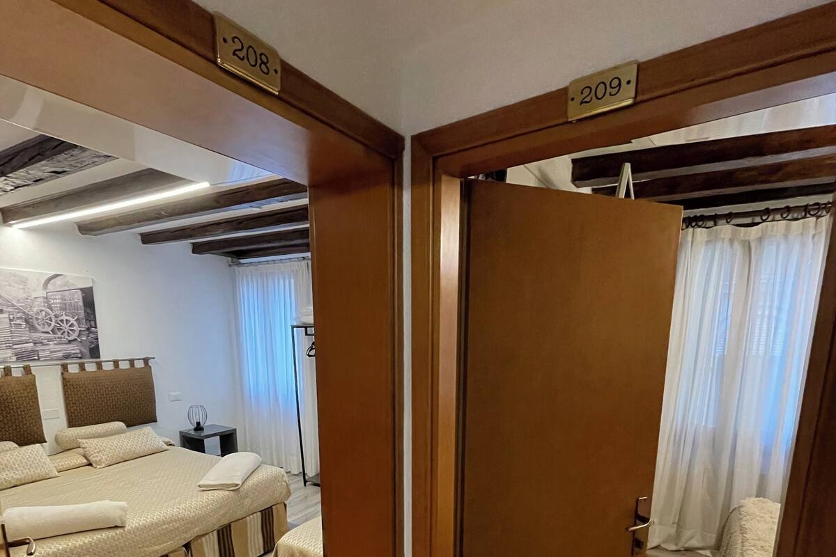Una habitación de hotel con una cama, una mesita de noche y un televisor montado en la pared.