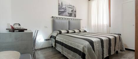 A modern bedroom with a bed, bedside table, and a chair.