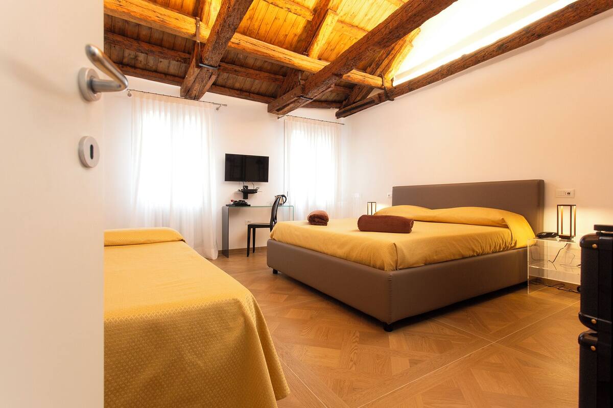 Un dormitorio con cama, escritorio y televisor.