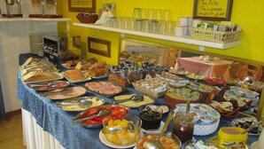 A buffet with various food items and utensils. - Casa Popi (Malcesine)