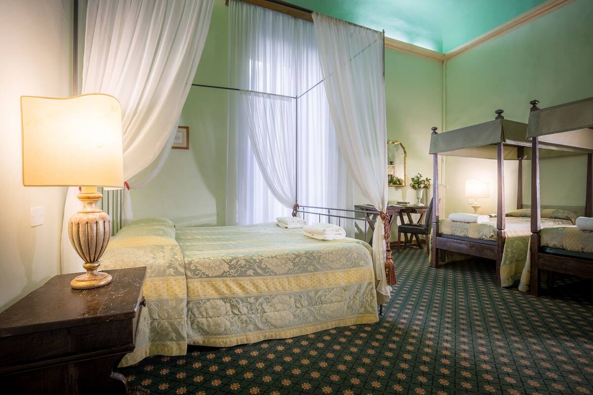 A room with a bed, a desk, a chair, and a bunk bed.