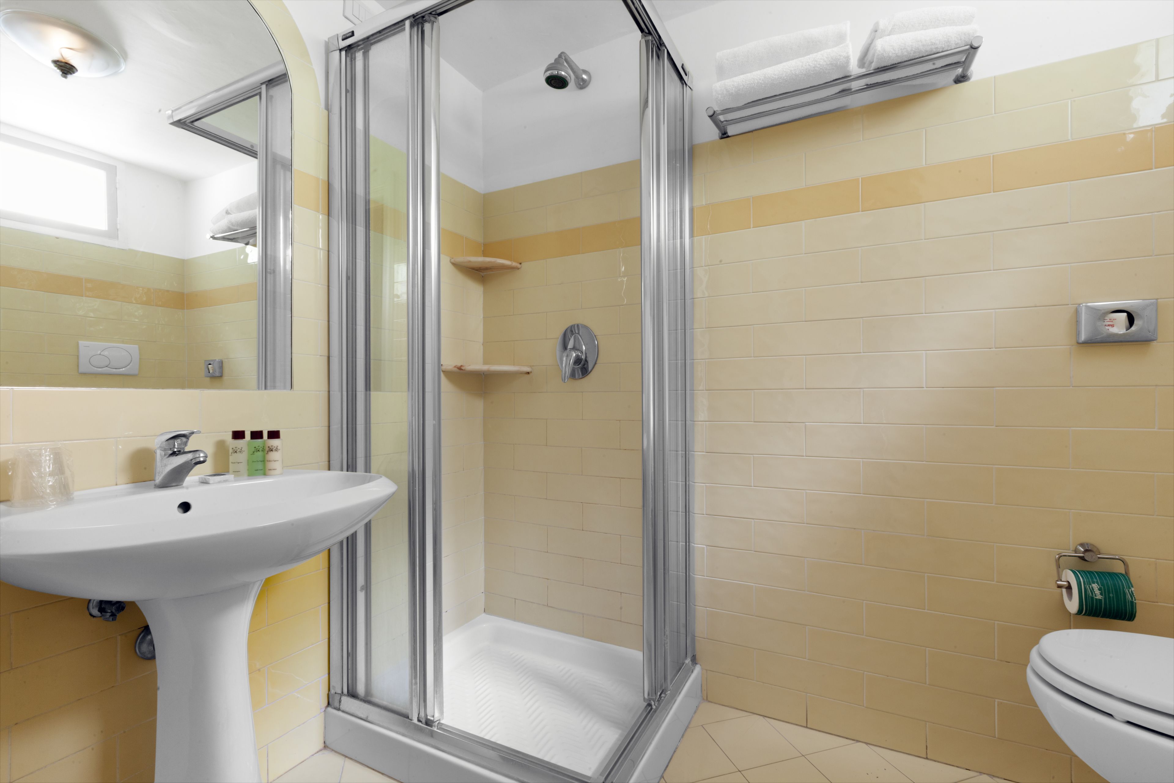 A bathroom with a shower, sink, and toilet.