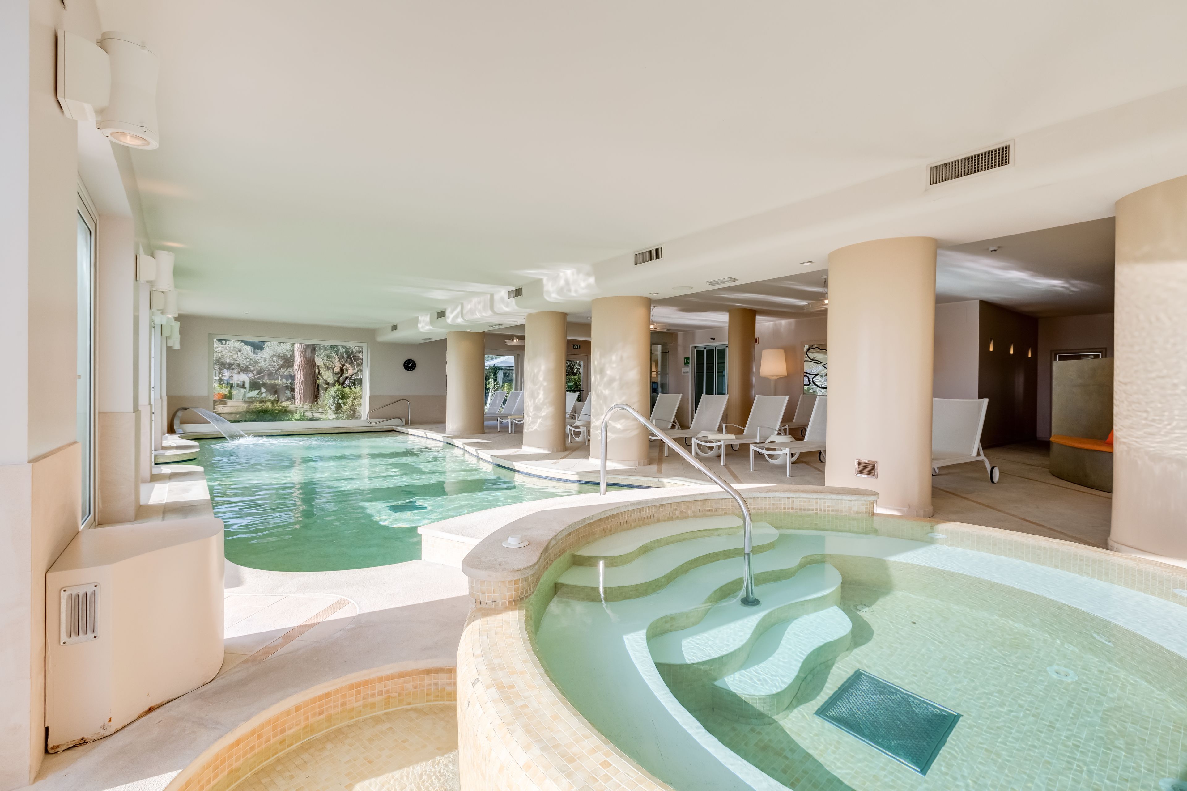 A pool area with multiple pools and lounge chairs.