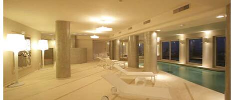 Un espace piscine avec des chaises longues et des piliers.