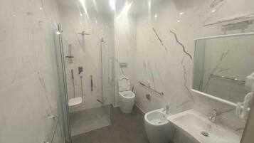 A modern bathroom with a glass-enclosed shower, a toilet, and a sink with a mirror.