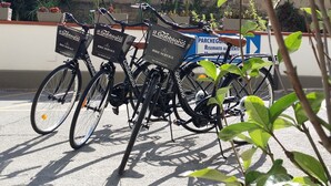 A row of bicycles with baskets labeled "Il Gabbiano Hotel Bike Service" parked in a lot. - Hotel Il Gabbiano (Termini Imerese)