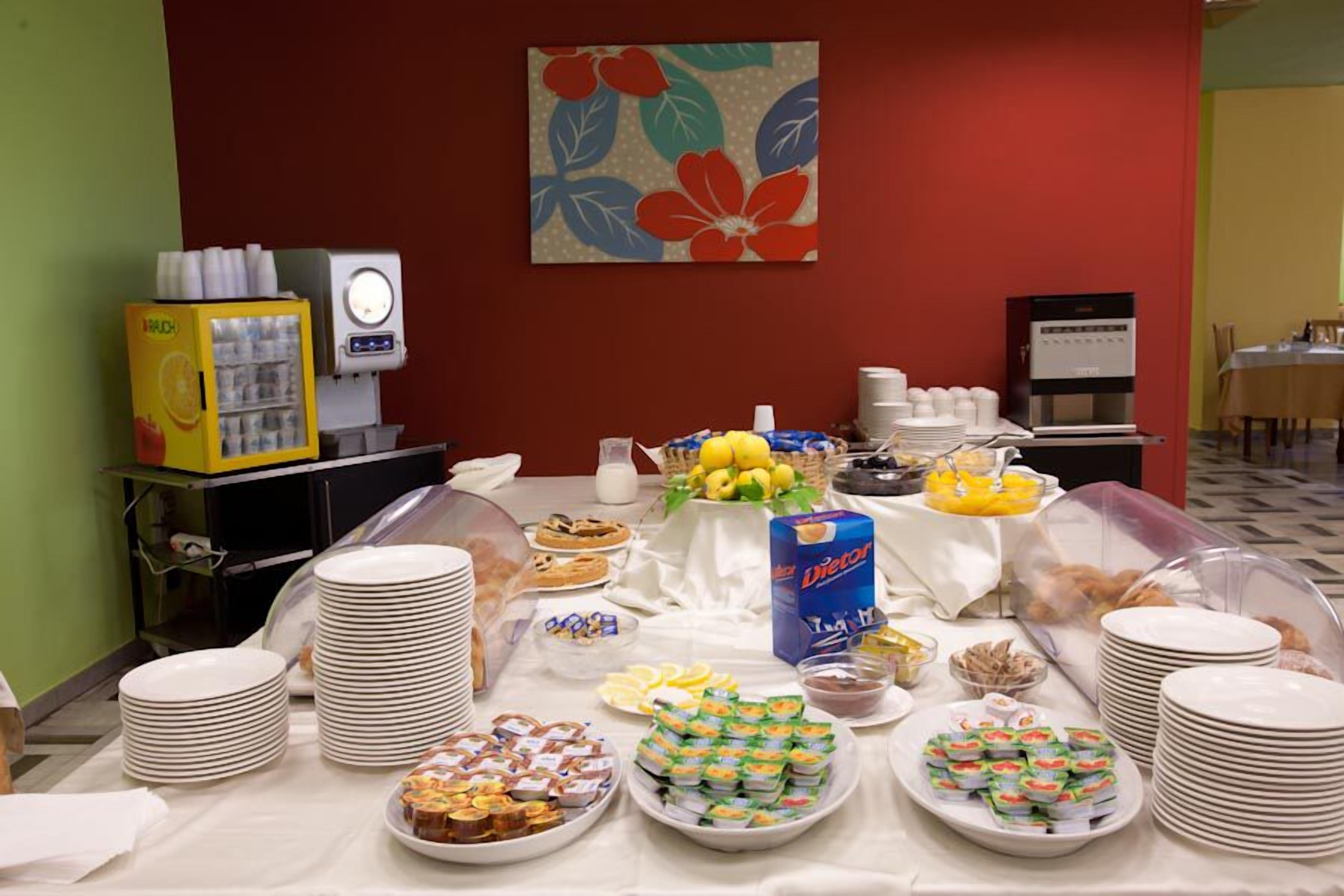 Une table de buffet avec divers plats, un réfrigérateur et une machine à café.