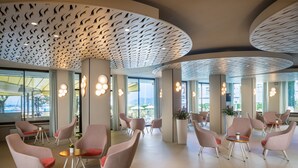 Un vestíbulo amplio con asientos modernos, ventanas grandes y un diseño de techo único.