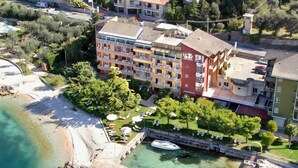 Ein Luftbild eines Küstenhotels mit Pool, Strand und Marina.