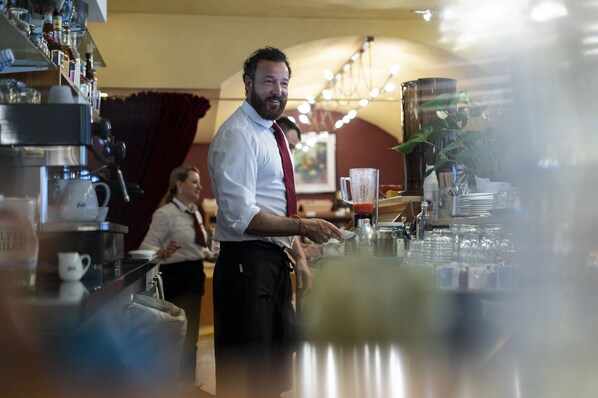 Una zona de bar con mostrador, distintos utensilios y una planta grande.