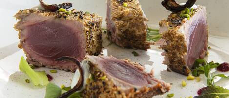 A plate of food with various cuts of meat and garnishes.