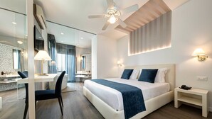 A modern hotel room with a large bed, a desk, and a chair. - Hotel Byron Bellavista (Jesolo)