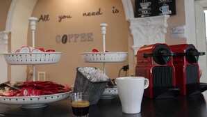 A coffee station with two baskets of coffee pods, a coffee machine, a cup, and a glass of coffee. - Hotel Salaria (Rome)