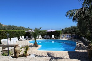 Een seizoensgebonden buitenzwembad en parasols bij het zwembad