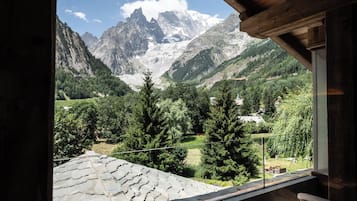 A wooden deck with a view of a mountainous landscape.
