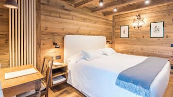 A wooden-paneled room with a bed, a desk, and a chair.