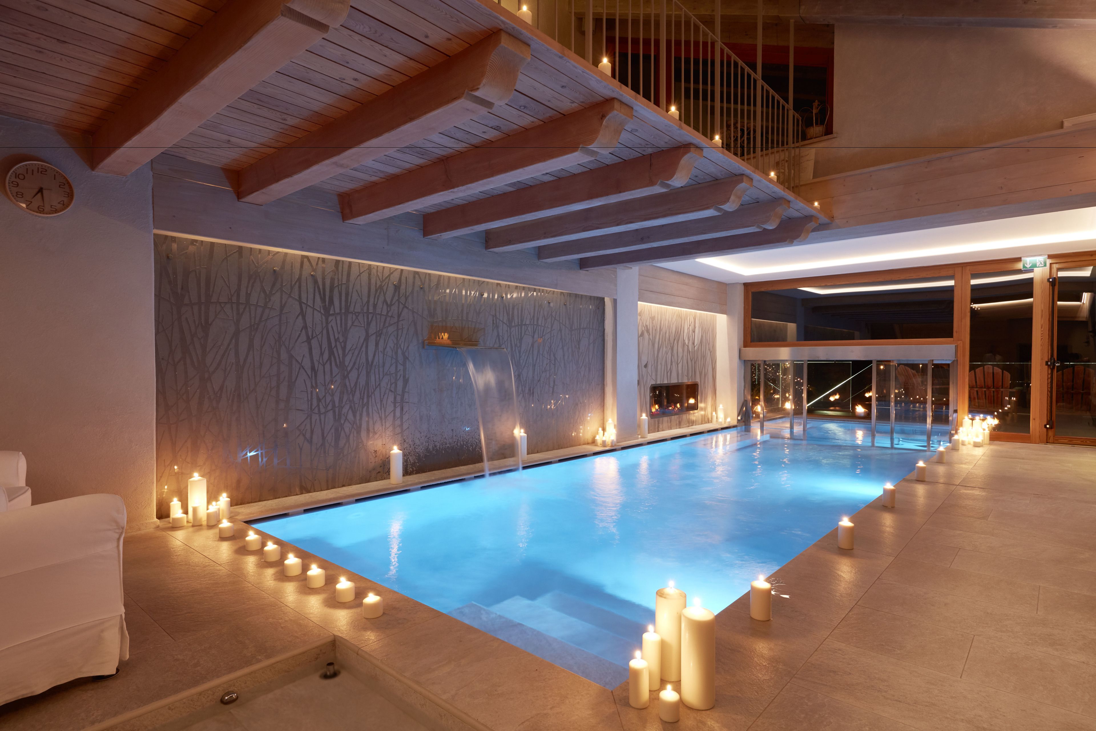 Una piscina interior moderna amb sostre de fusta i una paret amb disseny texturat.