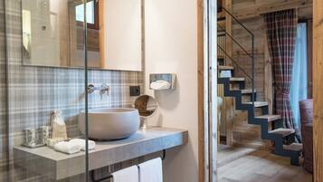 A modern bathroom with a large vessel sink, a mirror, and a towel rack.
