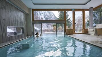 Relax by the pool with a serene view of the surrounding winter landscape.