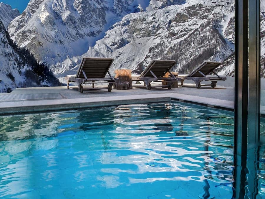 Una piscina cubierta, una piscina al aire libre, tumbonas