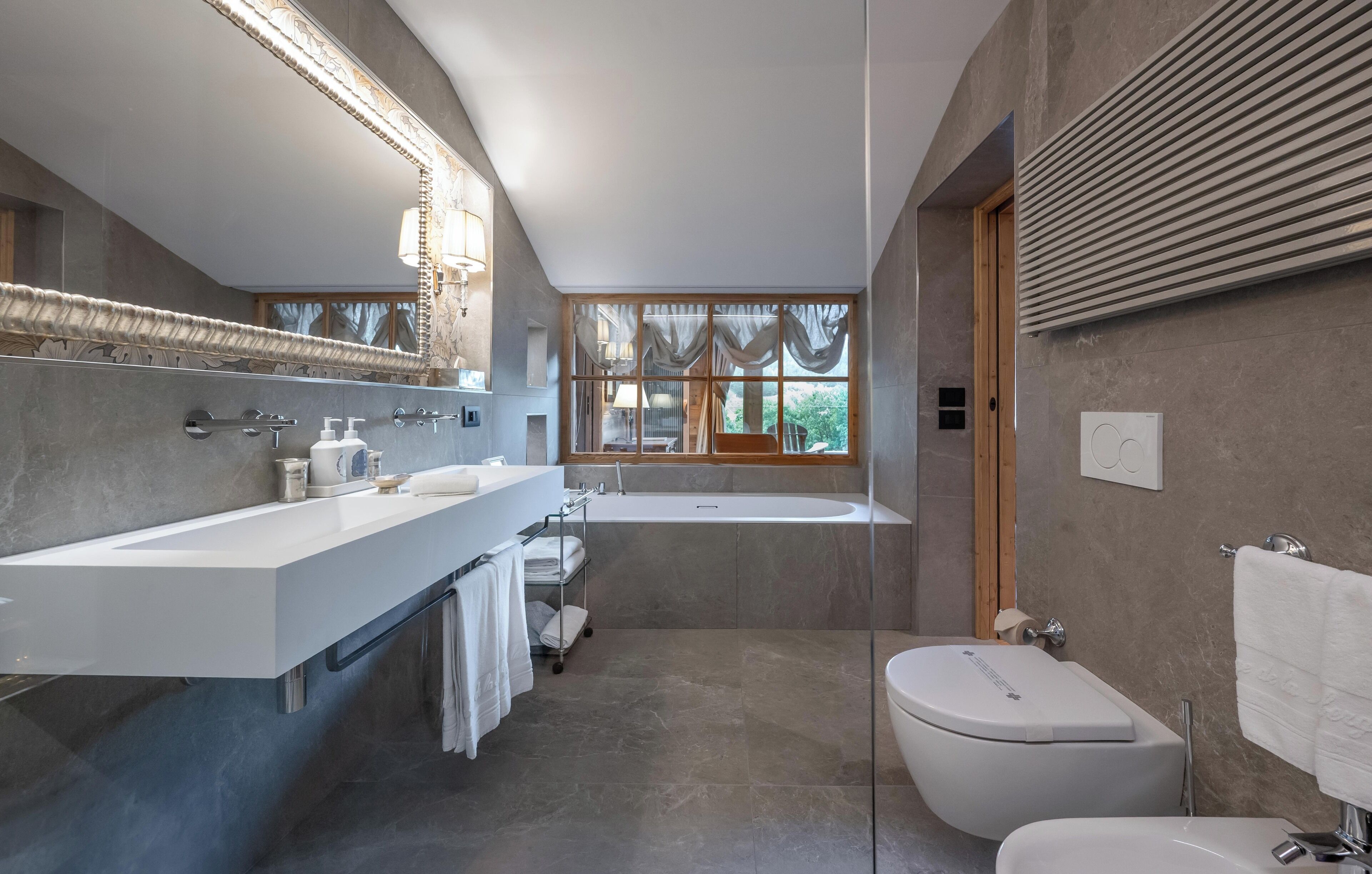 Une salle de bain moderne avec un grand meuble-lavabo, une baignoire et des toilettes.