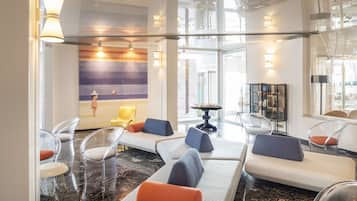 Ein moderner Lounge-Bereich mit klaren Glastrennwänden, bequemen Sitzgelegenheiten und stimmungsvoller Beleuchtung.