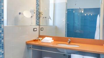 Et moderne badeværelse med et stort spejl, en bidet, en vask og et håndklædetørrestativ.