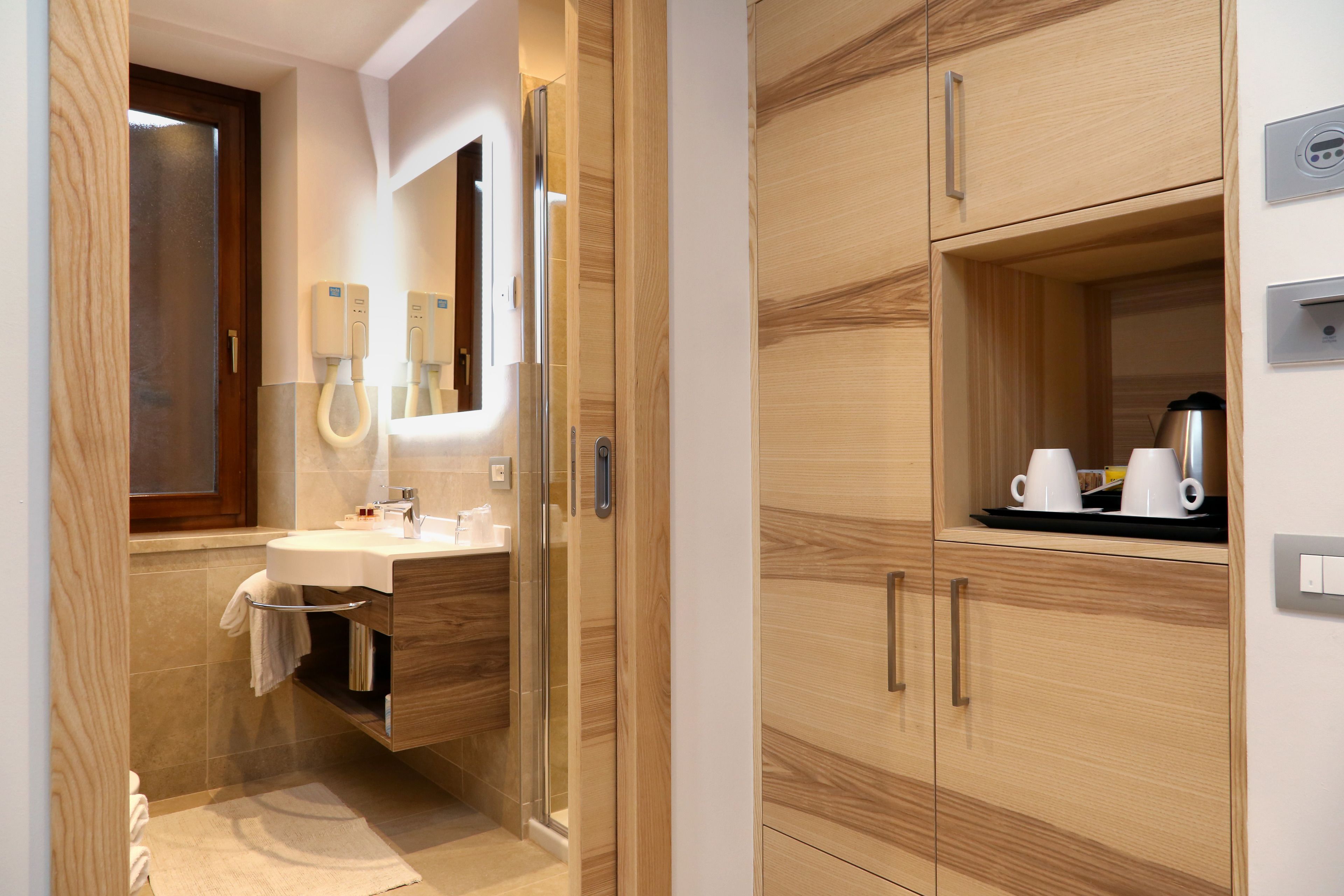 A modern bathroom with a glass-enclosed shower, a sink with a towel rack, and wooden cabinetry.