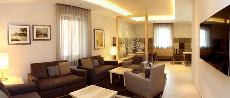 A modern living room with a sofa set, a coffee table, and a dining area with chairs and a table.