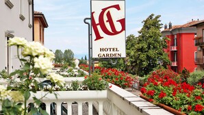 Een hotelsbord met een tuin op de achtergrond.