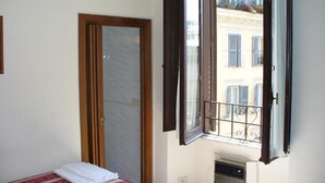 Une chambre à coucher avec un lit, une fenêtre et une porte.