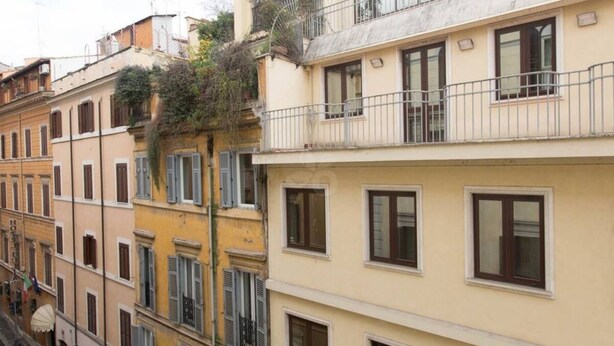 Une rangée d’immeubles à étages, dotés de balcons, de fenêtres et de portes.