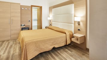 Un dormitorio moderno con cama, armario de madera, lámparas de noche y estante empotrado.