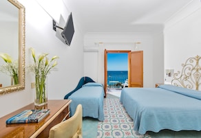 Habitación triple, balcón, vistas al mar | Edredones de plumas, minibar, caja fuerte y escritorio