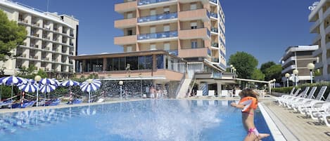 Una piscina al aire libre de temporada, sombrillas