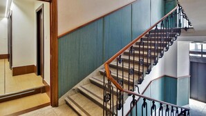 A staircase with wooden handrails and metal balusters, leading to an upper floor. - Hotel dei Mille (Rome)