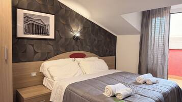 Ein Hotelzimmer mit einem Bett, einem Nachttisch, einer Wandlampe und einem gerahmten Bild.