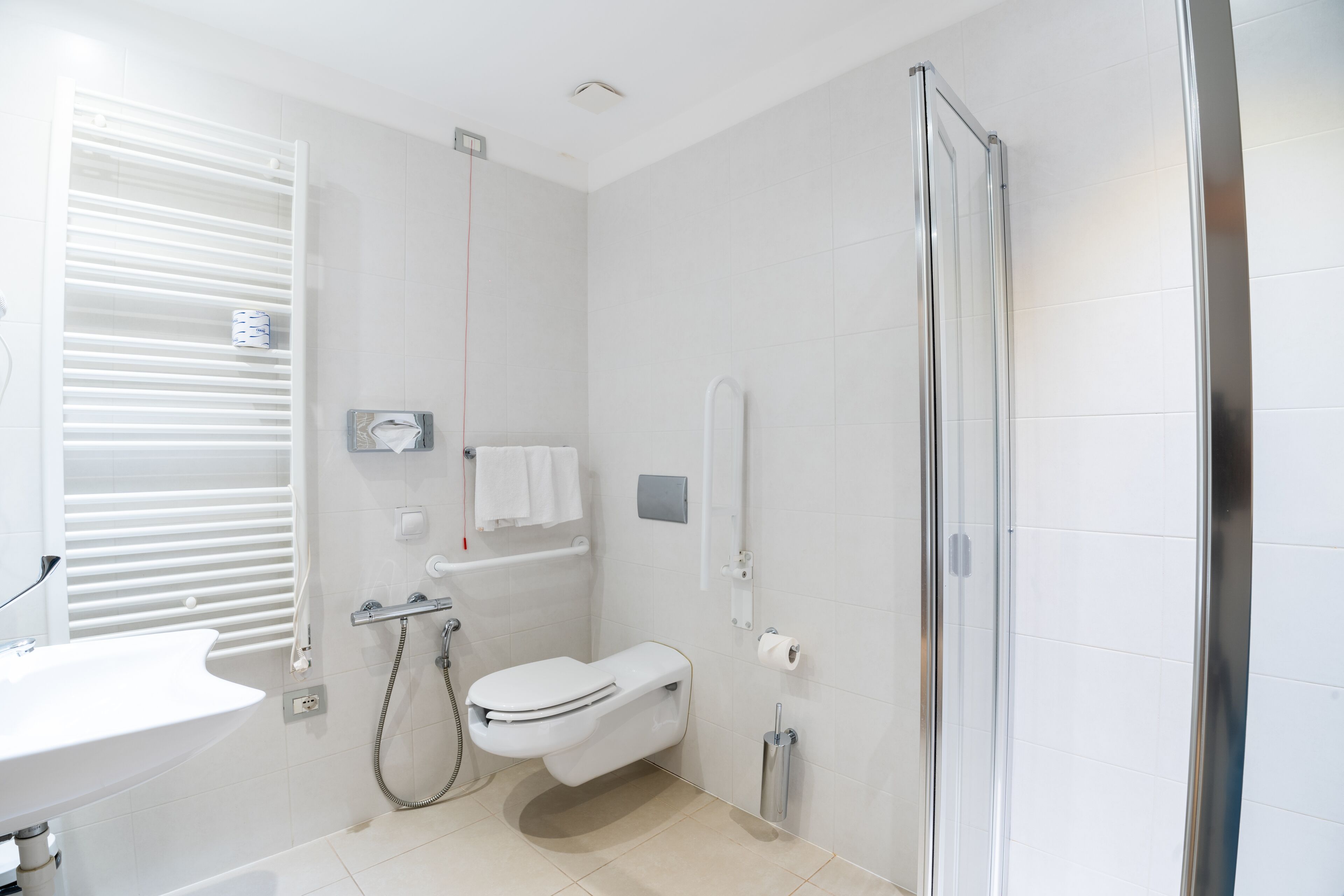 A modern bathroom with a toilet, sink, and shower.