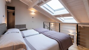 A bedroom with two beds, a skylight, a wooden ceiling, and a small closet. - Hotel Centrale (Cernobbio)