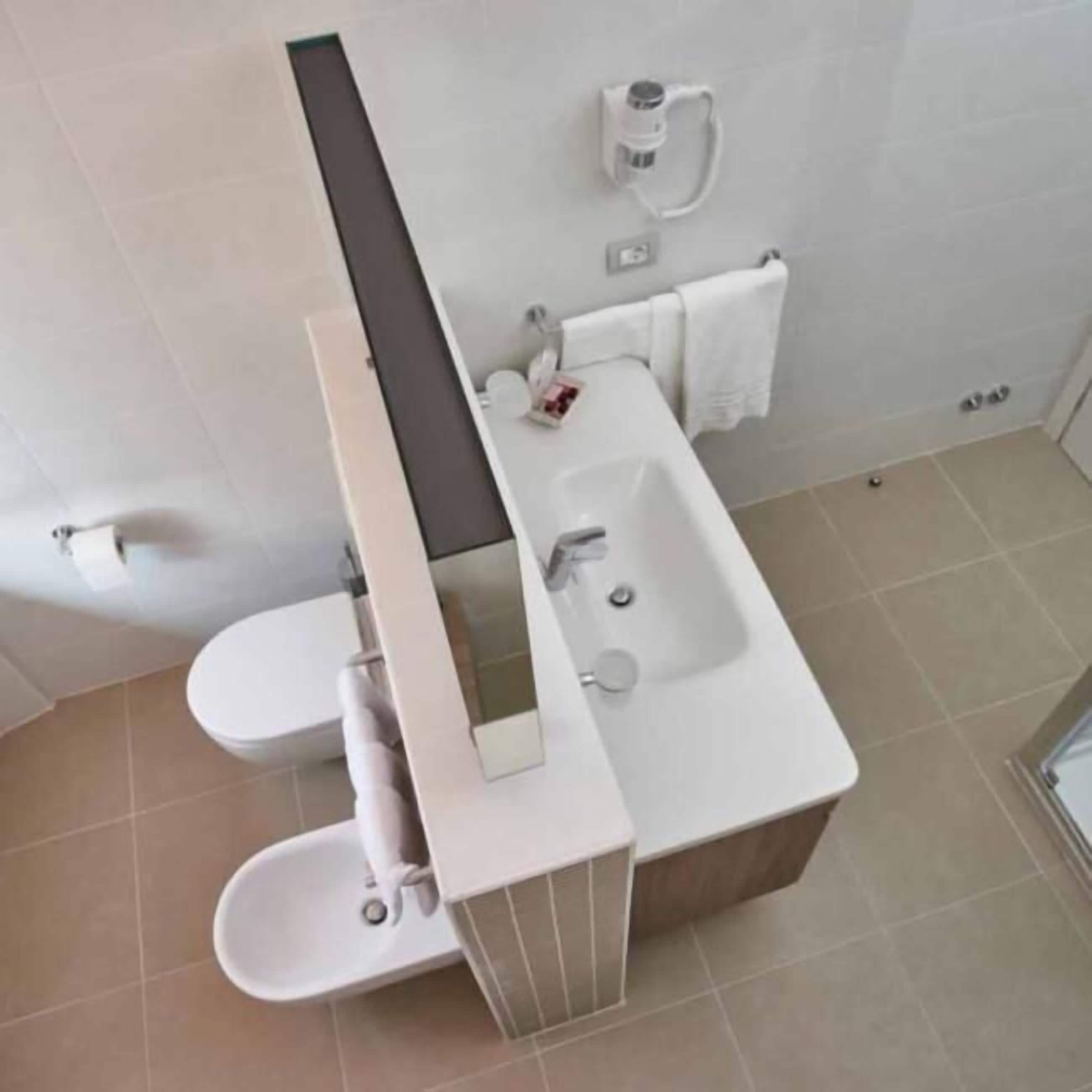 A modern bathroom with a toilet, bidet, and sink.