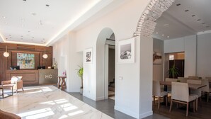 A spacious hotel lobby with a marble floor, a reception desk, and a dining area with chairs and tables. - Hotel Centrale (Cernobbio)