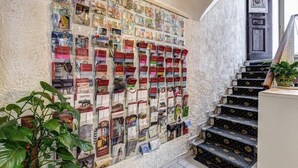 A wall with a collection of postcards and a staircase with floral patterned steps.