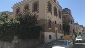 A historic building with a classic facade, a central entrance, and a small balcony.