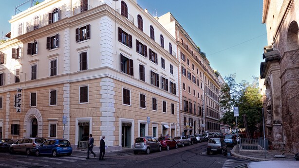 Un hotel de varios pisos con un estilo arquitectónico clásico, que presenta una entrada destacada y varias ventanas.