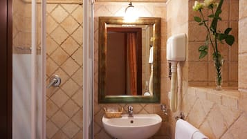 Un baño con ducha, lavamanos y espejo.