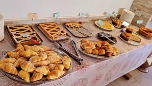 A buffet with various baked goods, including pies, tarts, and pastries.