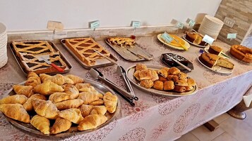 Un bufé con diversos productos de pastelería, como tartas, pasteles y hojaldres.