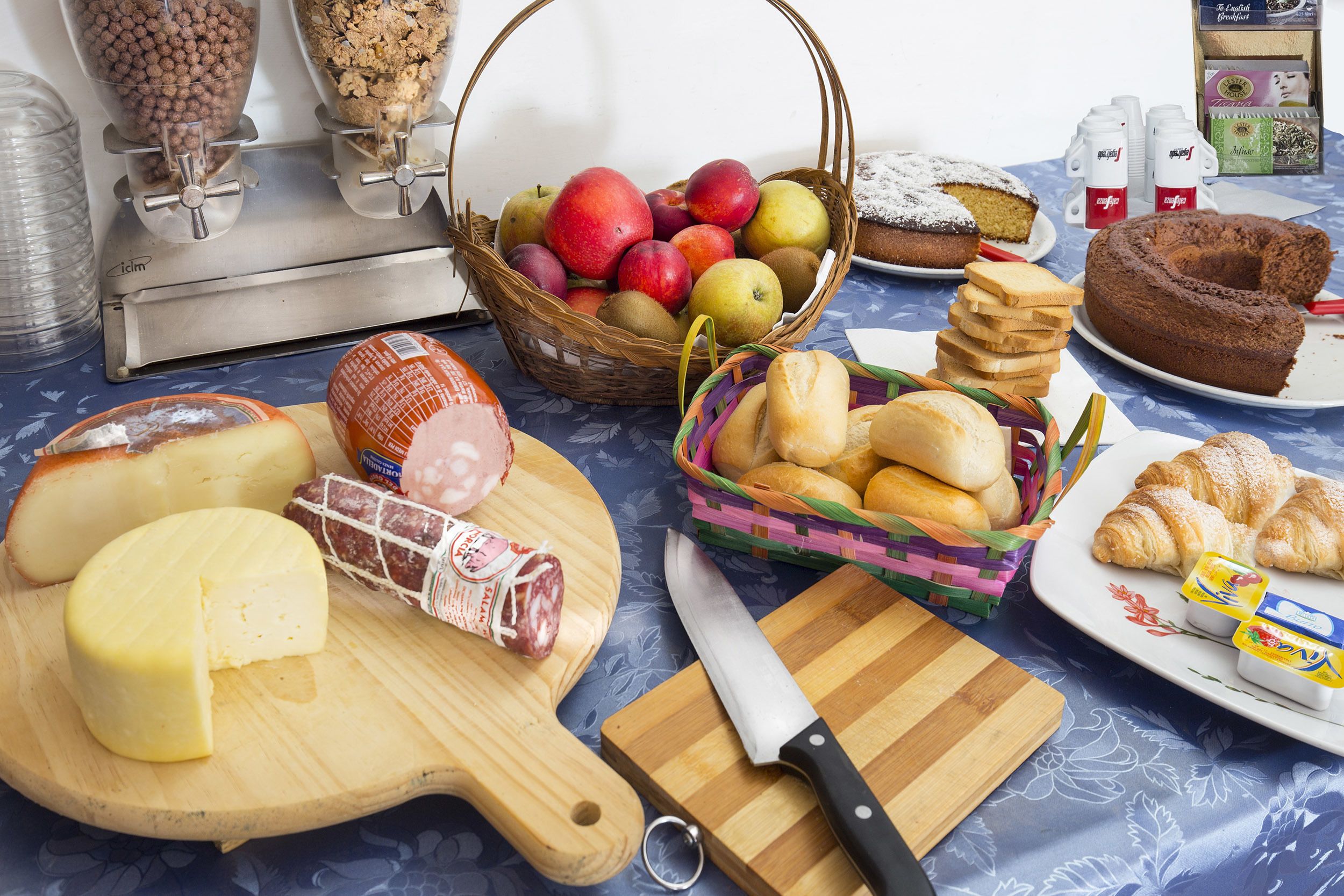 A table with various food items including fruits, bread, cheese, and pastries.