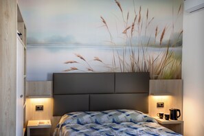 A bedroom with a bed, a nightstand, a wall-mounted shelf, and a wall mural of a lake. - Hotel La Darsena (Passignano sul Trasimeno)