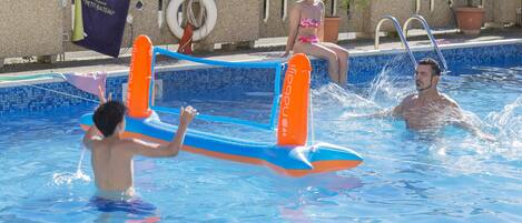 Una piscina con juguetes inflables y un banderín.
